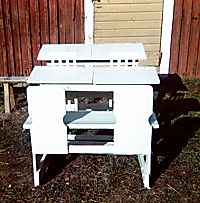 Juuri maalattu koulun vanha pulpetti ulkorakennuksen seinustalla